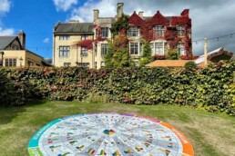 A picture of a garden with a pretty house and a mat on the floor for a learning and development workshop