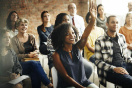 a lady raising her hand in a training session